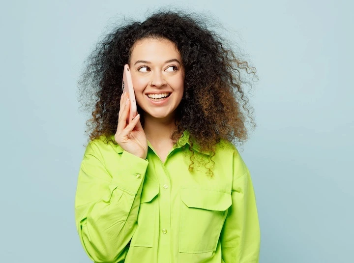 A smiling brunette woman talking on the phone